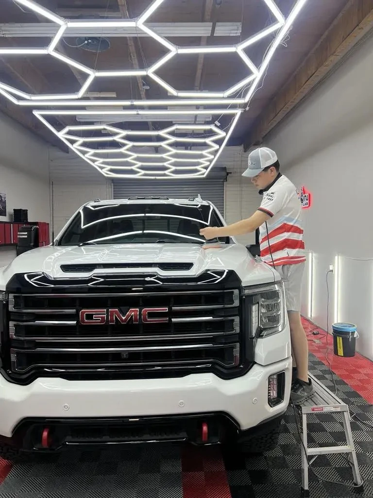 Technician detailing a white pickup truck