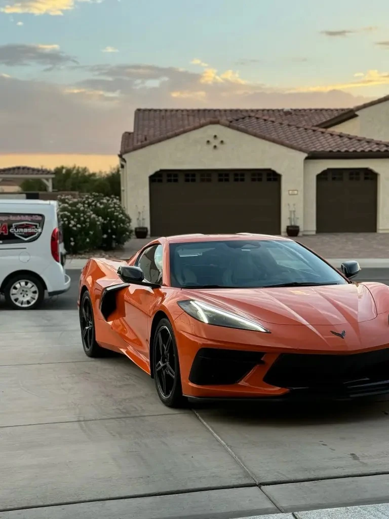 Orange sports car photographed at a customer location