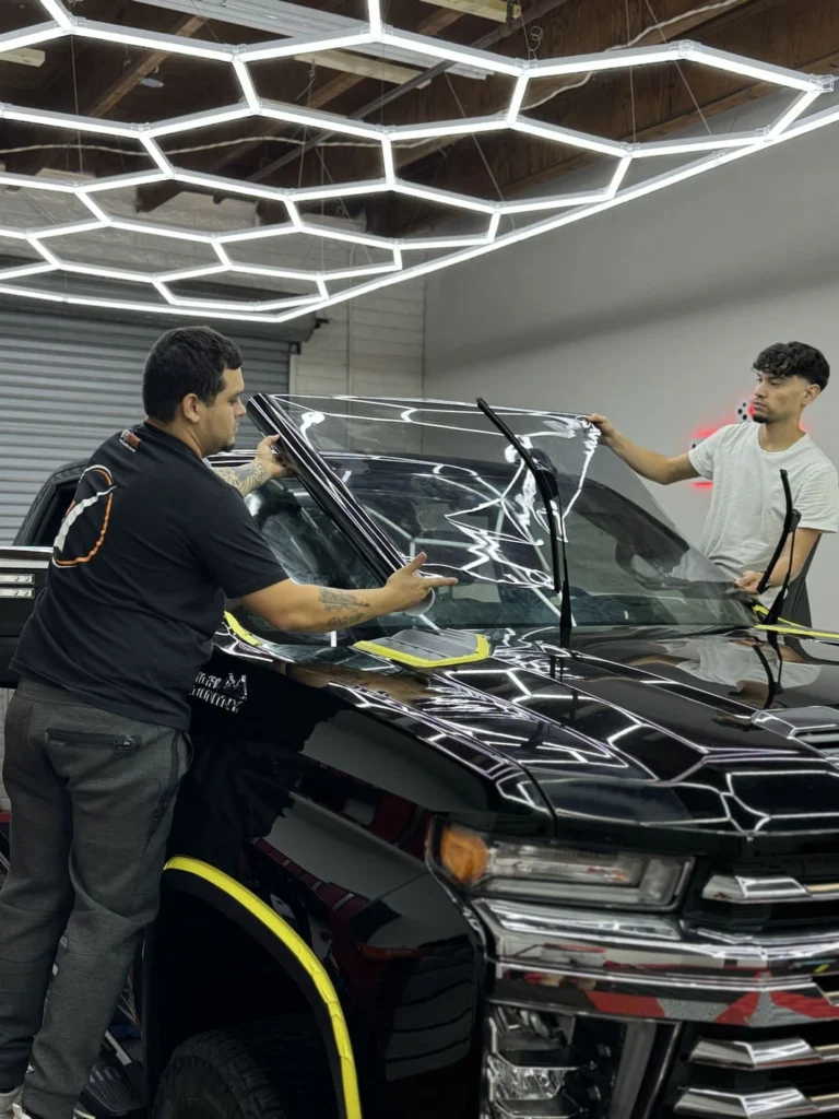 ICON Auto Lab — technicians installing film on an automotive windshield